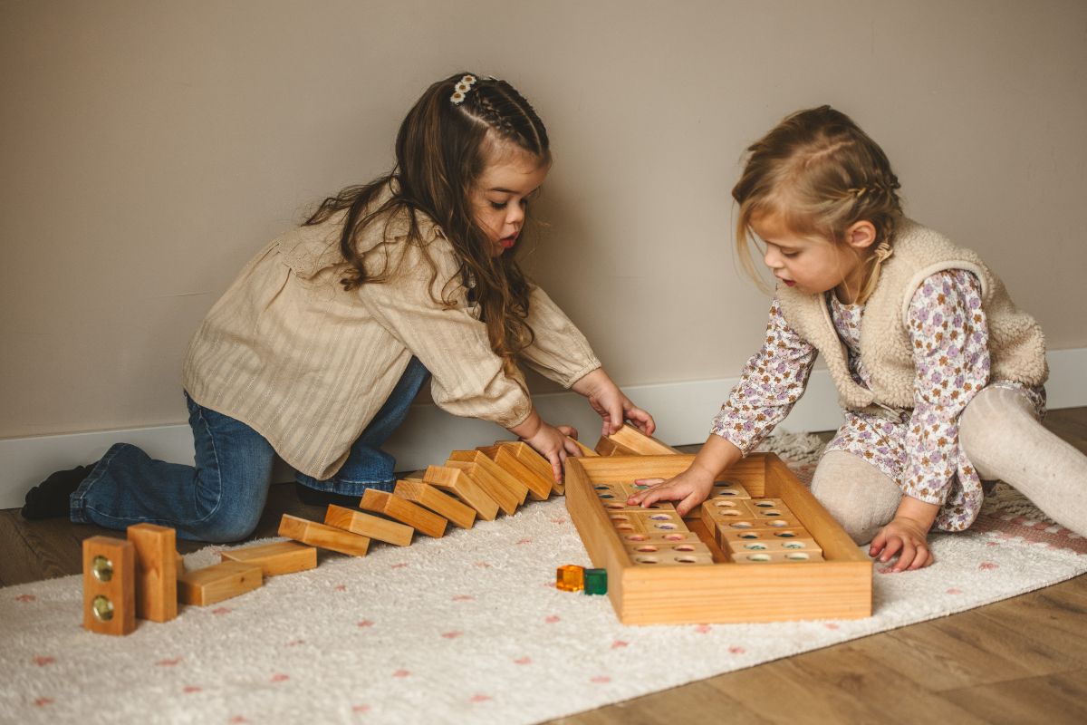 Kinderen spelen met houten blokken. Een voorbeeld van montessori speelgoed